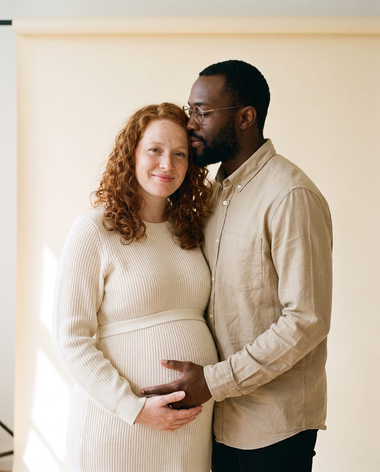 Un couple, elle enceinte de huit mois, les mains posées sur le ventre