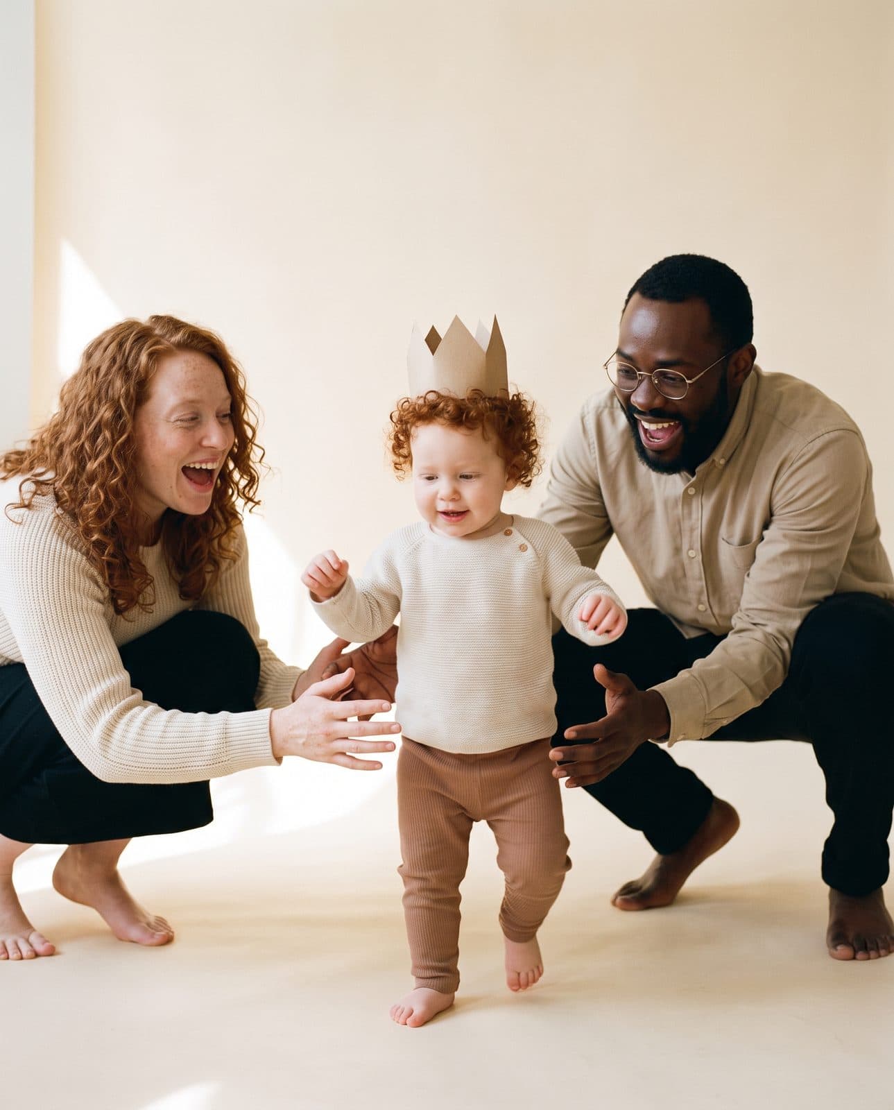 Jeanne à un an, couronne en papier, ses premiers pas entre les mains de ses parents