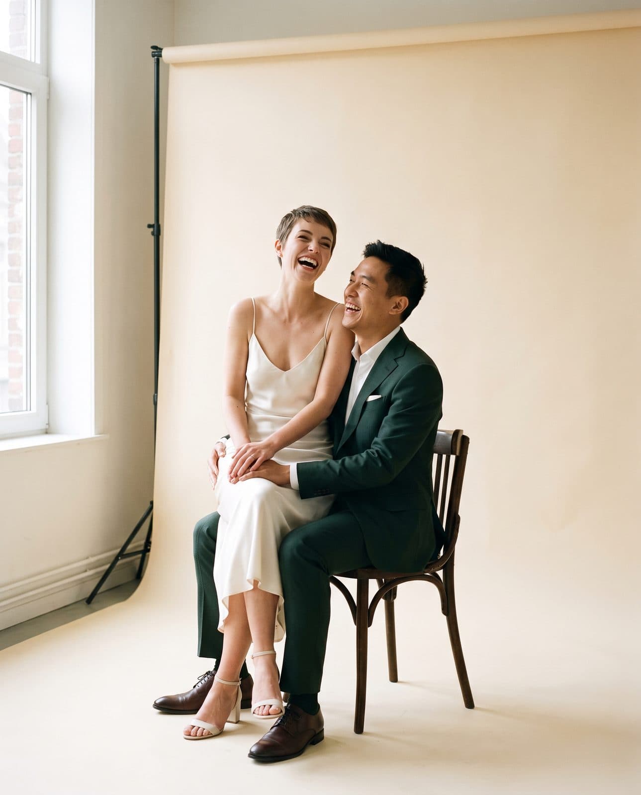 Un couple en tenue de mariage sur une chaise bistrot